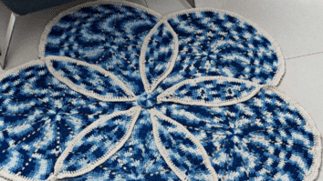 Almofada de crochê e tapete azul e cru