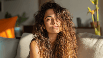 Imagem gerada por IA de mulher com cabelos cacheados exemplificando uma mulher que esta fazendo transição capilar