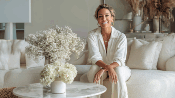 Mulher sorridente sentada em sofá claro em sala elegante decorada com flores brancas