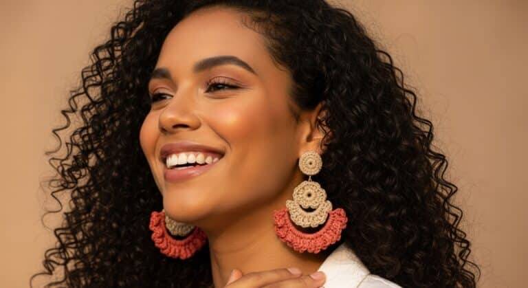 Mulher brasileira elegante usando brincos de crochê coloridos feitos à mão, com luz natural suave e fundo neutro, representando moda artesanal e estilo boho.