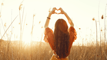 Mulher fazendo símbolo de coração com as mãos simbolizando otimismo