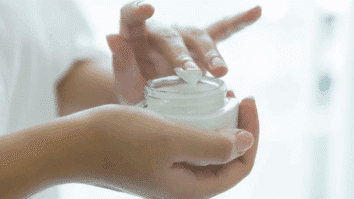 Pote de creme antissinais em uma mão, creme destinado à suavizar rugas e linhas de expressão