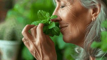 Imagem gerada por IA de mulher de cabelos grisalhos cheirando uma folha de hortelã, cercada por plantas verdes — imagem que representa o bem-estar e os benefícios das plantas para a saúde física.