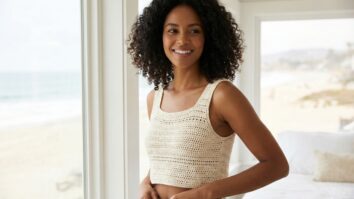 Mulher brasileira em blusa de crochê cru em quarto arejado com vista para a praia