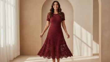 Mulher brasileira sorrindo usando vestido de crochê em tom vinho com modelagem midi vazada e textura rica em ambiente editorial