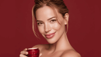 Mulher segurando um pote de creme facial nas mãos