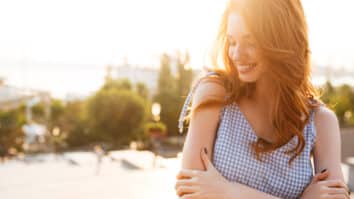 Mulher com semblante feliz em uma praça