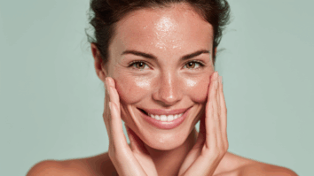 Mulher tocando a pele do rosto com semblante feliz