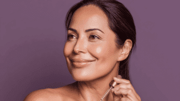 Mulher segurando um aplicador de sérum em uma das mãos, exibindo um rosto com firmeza e viço na pele