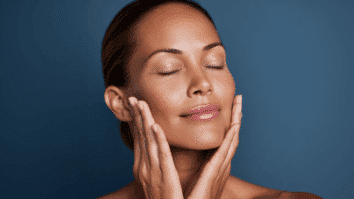 Mulher com as mãos no rosto sentindo a textura da pele