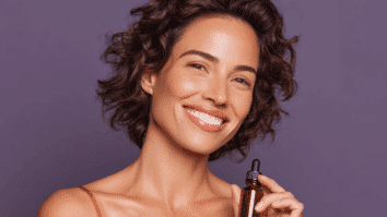 Mulher segurando produto para cuidados com a pele na mão