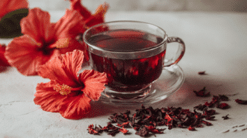 Flores e uma xicara de chá de hibisco na imagem