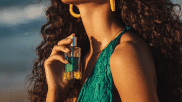 Mulher borrifando perfume no pescoço