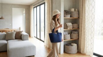 Ambiente integrado com cortinas, cestos e mulher usando bolsa e chapéu de crochê moderno em tons neutros