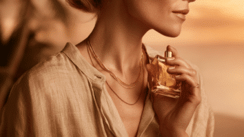 Mulher borrifando perfume no pescoço