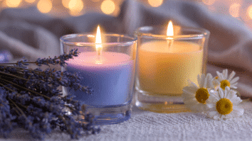 Levanda, velas aromáticas e camomila dispostas sobre uma toalha