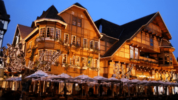 Imagem de Campos do Jordão com arquitetura alpina iluminada à noite, típica da Vila Capivari.