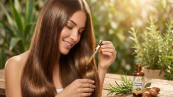 Mulher aplicando óleo de alecrim com argan no cabelo
