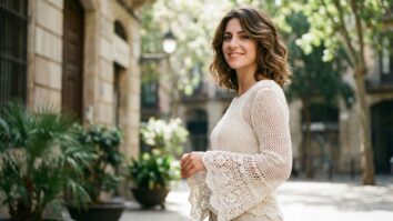 Mulher sorrindo usando blusa de crochê off-white com mangas sino e textura rendada