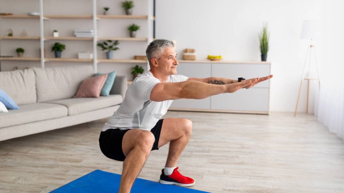 Homem fazendo exercício de agachamento em casa