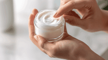 Mulher com um pote de creme anti-idade nas mãos