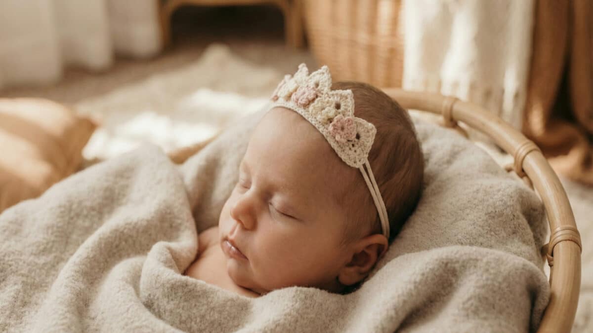 Bebê dormindo usando uma tiara feita de crochê