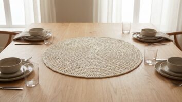 Cena editorial de sala de jantar sofisticada com centro de mesa em crochê artesanal redondo ou oval, elegante e contemporâneo, confeccionado em fio de algodão nobre com toque metalizado sutil.