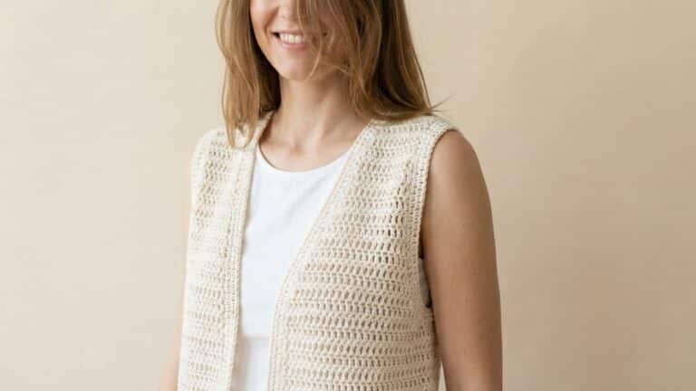 Mulher usando colete de croche off-white leve e arejado ideal para verao brasileiro em estudio moderno
