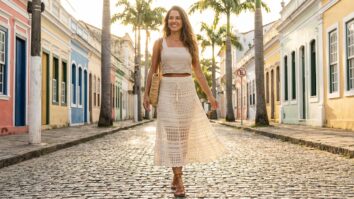 Mulher sorrindo com saia midi de crochê off-white em estilo boho contemporâneo