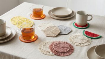 Mesa posta com porta-copos de crochê em formatos de frutas, hexágonos e estilo boho ao redor de copos