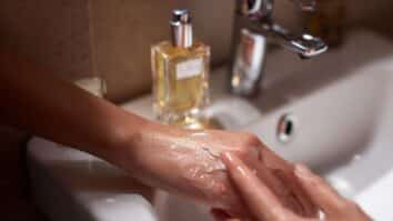 Mulher passando vaselina na mão para fixar perfume