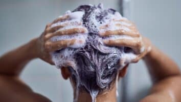 Mulher lavando cabelo com shampoo roxo