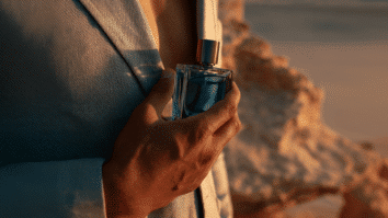 Homem com frasco de perfume na mão