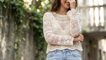 Mulher em ambiente urbano brasileiro usando blusa de croche artesanal off-white com trama aberta e jeans claro