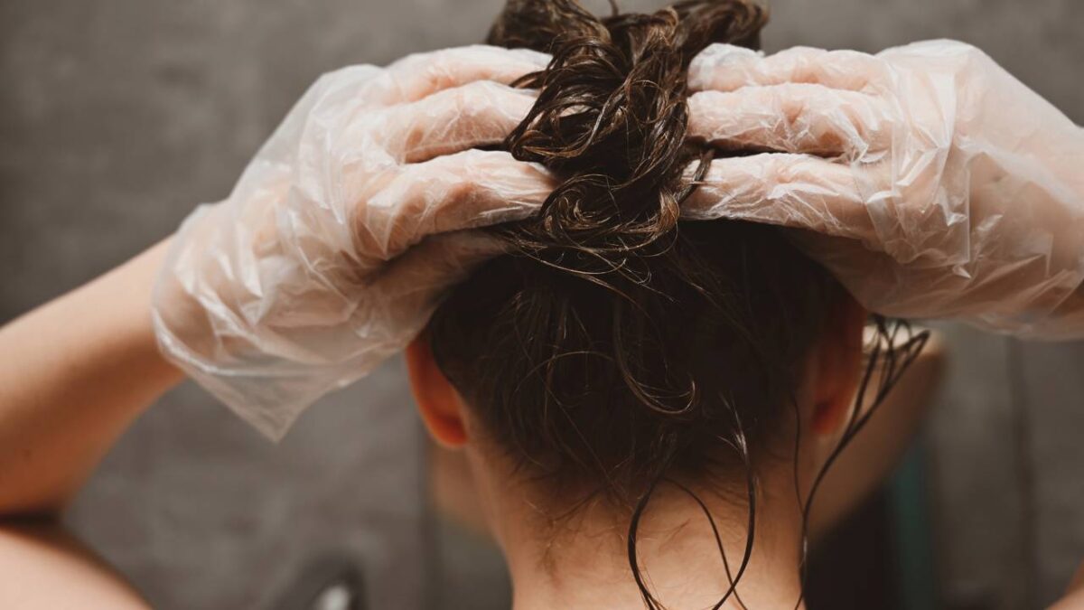 Mulher pintando o próprio cabelo em casa