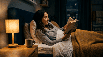essoa lendo um livro na cama com luz baixa