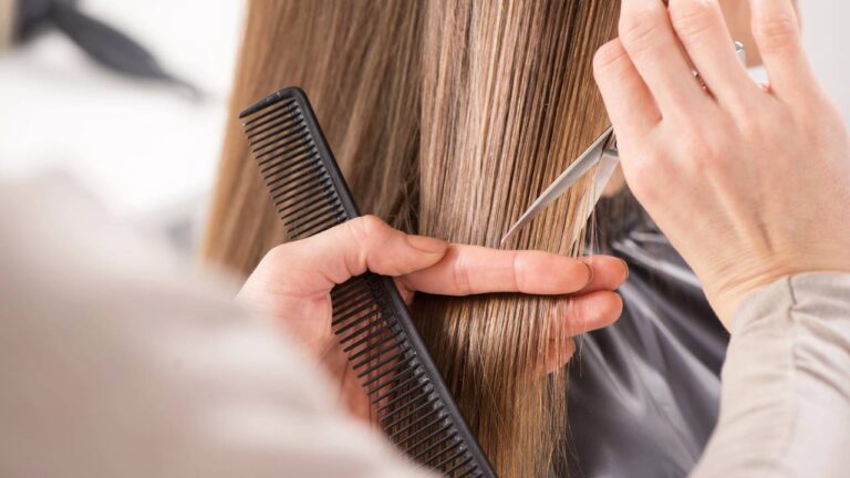 Profissional cortando cabelo de mulher em salão