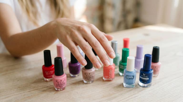 Mão feminina escolhendo o esmalte