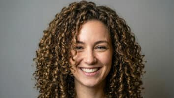 Mulher com cabelo cacheado sorrindo