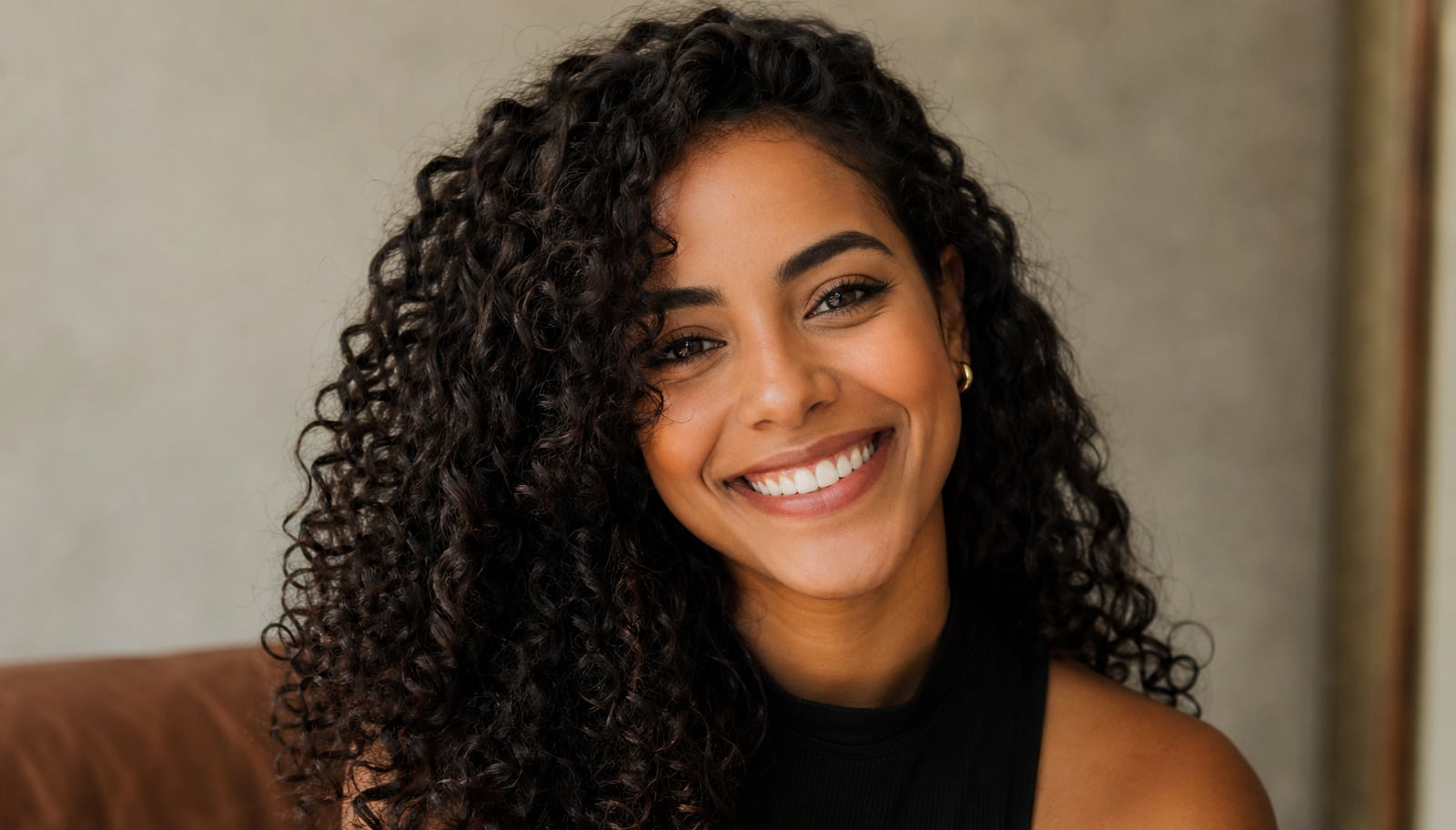 Mulher com cabelo cacheado sorrindo