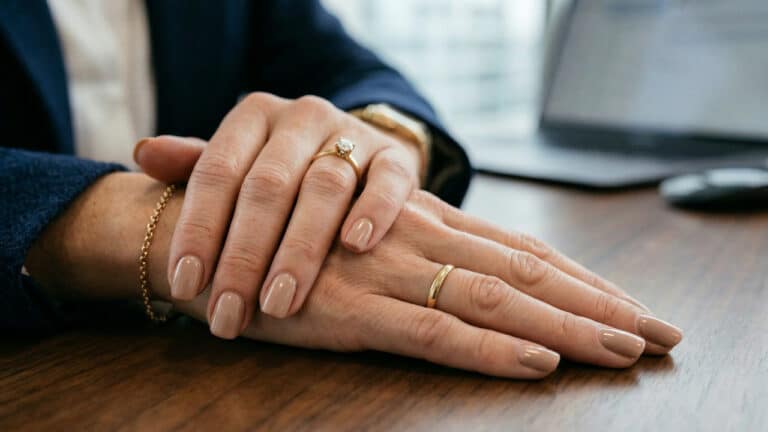 Mulher com veste corporativa, foco nas unhascor nude