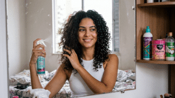 Muher borrifando produto no cabelo