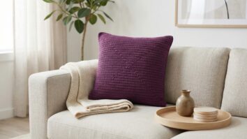Sala de estar moderna com decoracao brasileira e almofada de croche artesanal em roxo escuro sobre sofa neutro, estilo contemporaneo minimalista