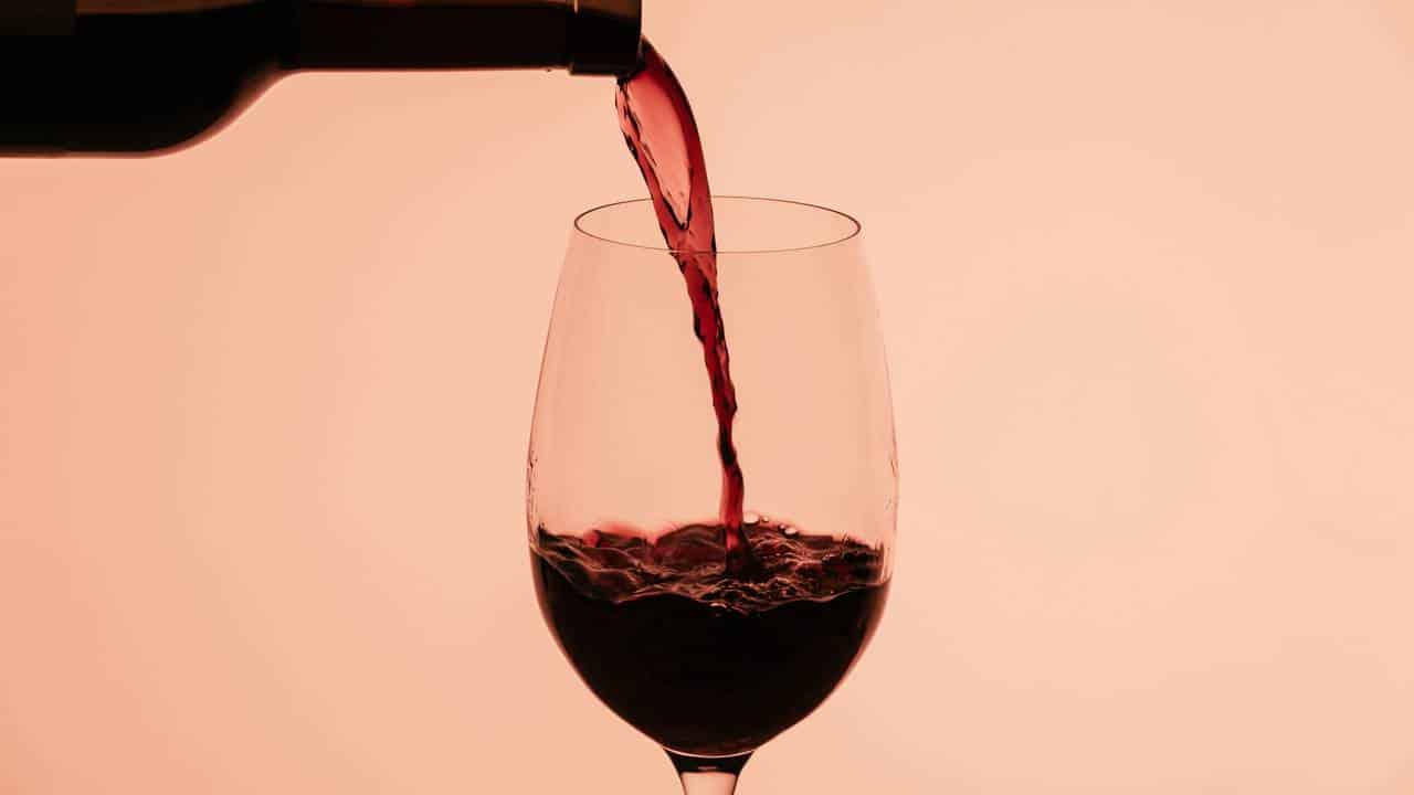 Servindo taça de vinho tinto