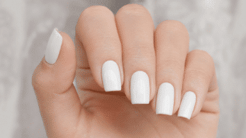 Unhas com esmalte branco perfeito, mostrando o acabamento uniforme e brilhante