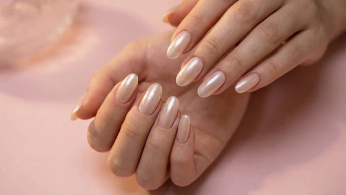 Unha nude perolado com o fundo rosado.