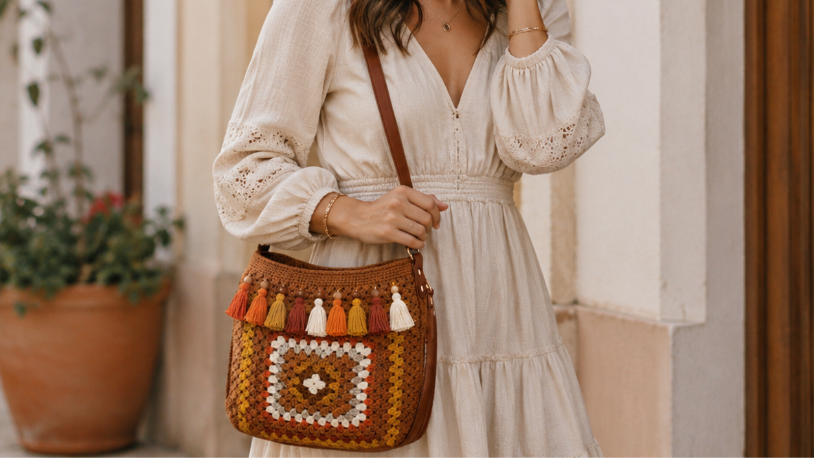 Mulher usando bolsa de crochê marrom com franjas coloridas em look leve e artesanal.