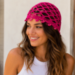 Mulher usando touca rosa de crochê vazada em ponto rede, com acabamento delicado e estilo artesanal para looks leves e criativos.