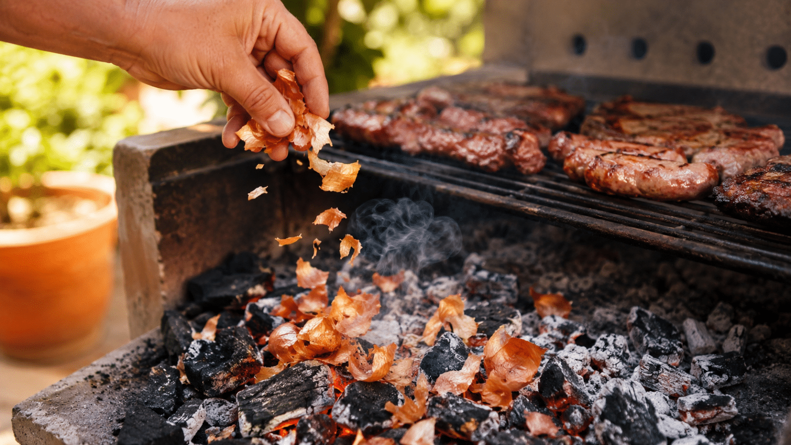 Cascas de cebola sendo jogadas nas brasas da churrasqueira para aromatizar o churrasco de forma simples e caseira.