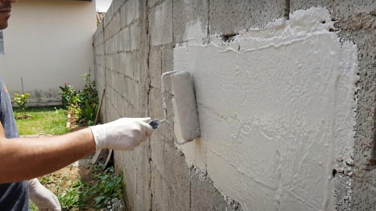 Homem aplicando tinta emborrachada na área externa da casa